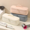 A beige and gray storage bag for a hair dryer, showing the partitioned compartments and an attached cord.