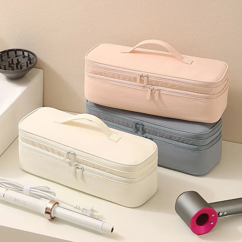 A beige and gray storage bag for a hair dryer, showing the partitioned compartments and an attached cord.