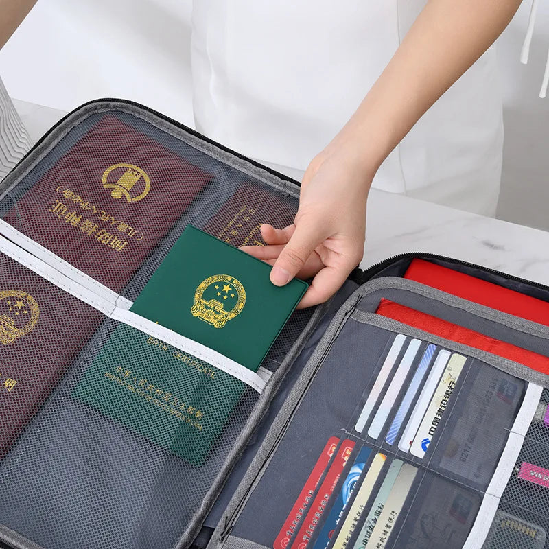 A hand is opening a fireproof document storage bag with multiple compartments and folders.