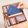 A brown leather passport holder wallet with multiple slots and a wristlet strap, featuring various colored cards.
