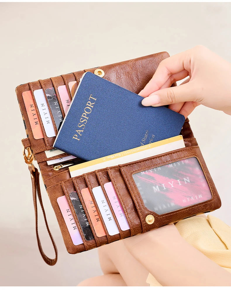 A brown leather passport holder wallet with multiple slots and a wristlet strap, featuring various colored cards.