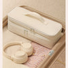 A beige durable travel hair dryer storage bag with partitioned compartments resting inside a light brown box.