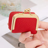 Una caja de almacenamiento de joyas de terciopelo rojo mini con detalles dorados sostenida en la mano de una persona.