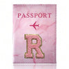 Pink marbled passport cover featuring a gold initial R and a pink airplane design.