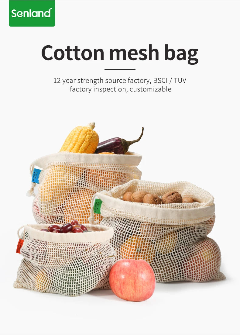 A collection of reusable cotton mesh bags filled with various produce like corn, eggplant, and apples.