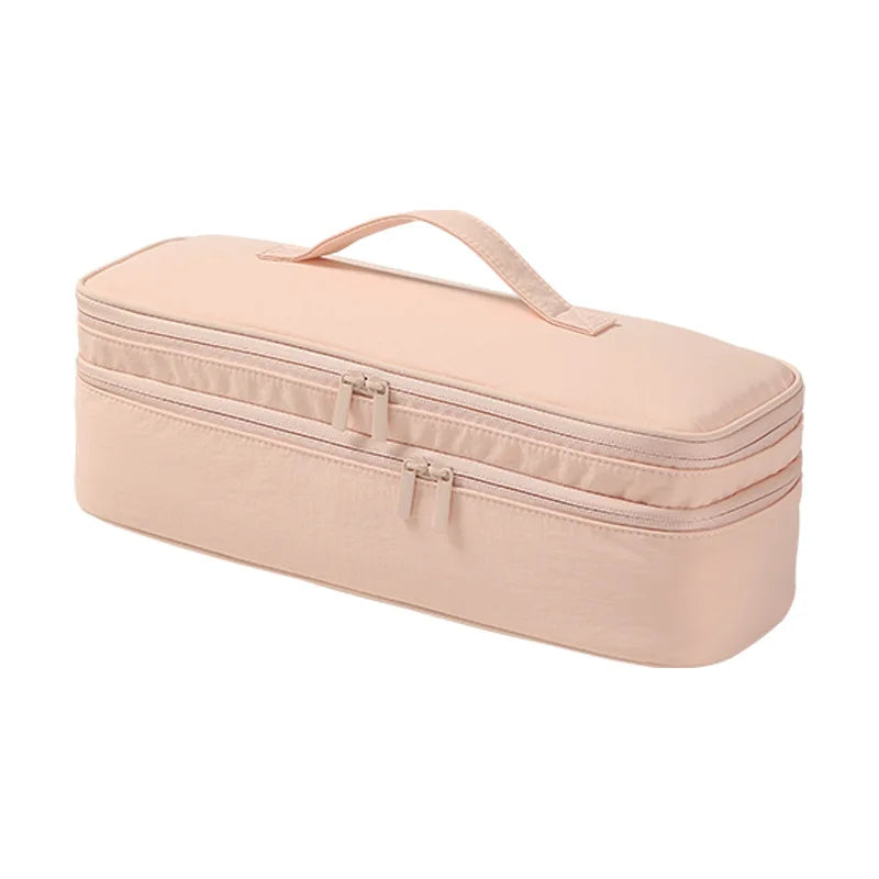 A light pink durable travel hair dryer storage bag with a handle and partitioned compartments.