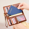 A brown leather passport holder wallet with multiple card slots and a blue passport visible.