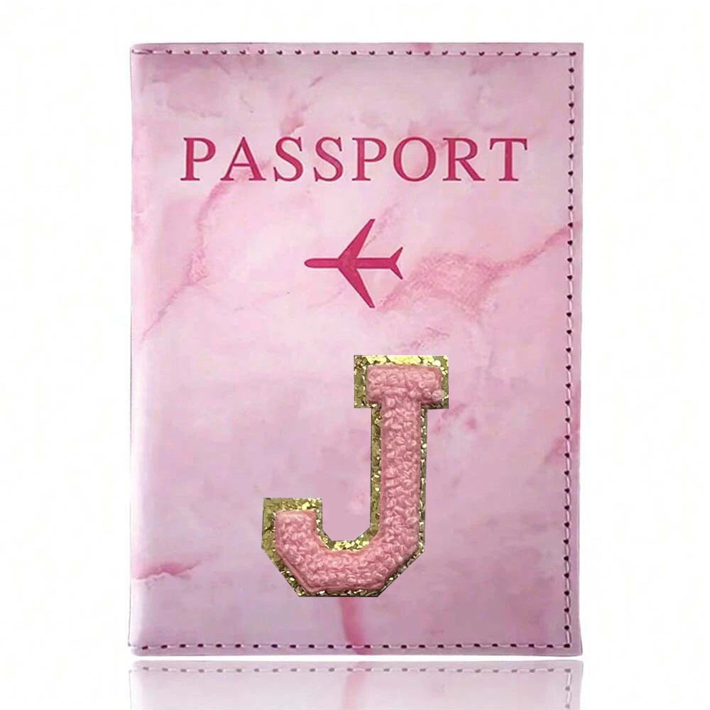 Pink marbled passport cover featuring a gold initial J and a pink airplane emblem