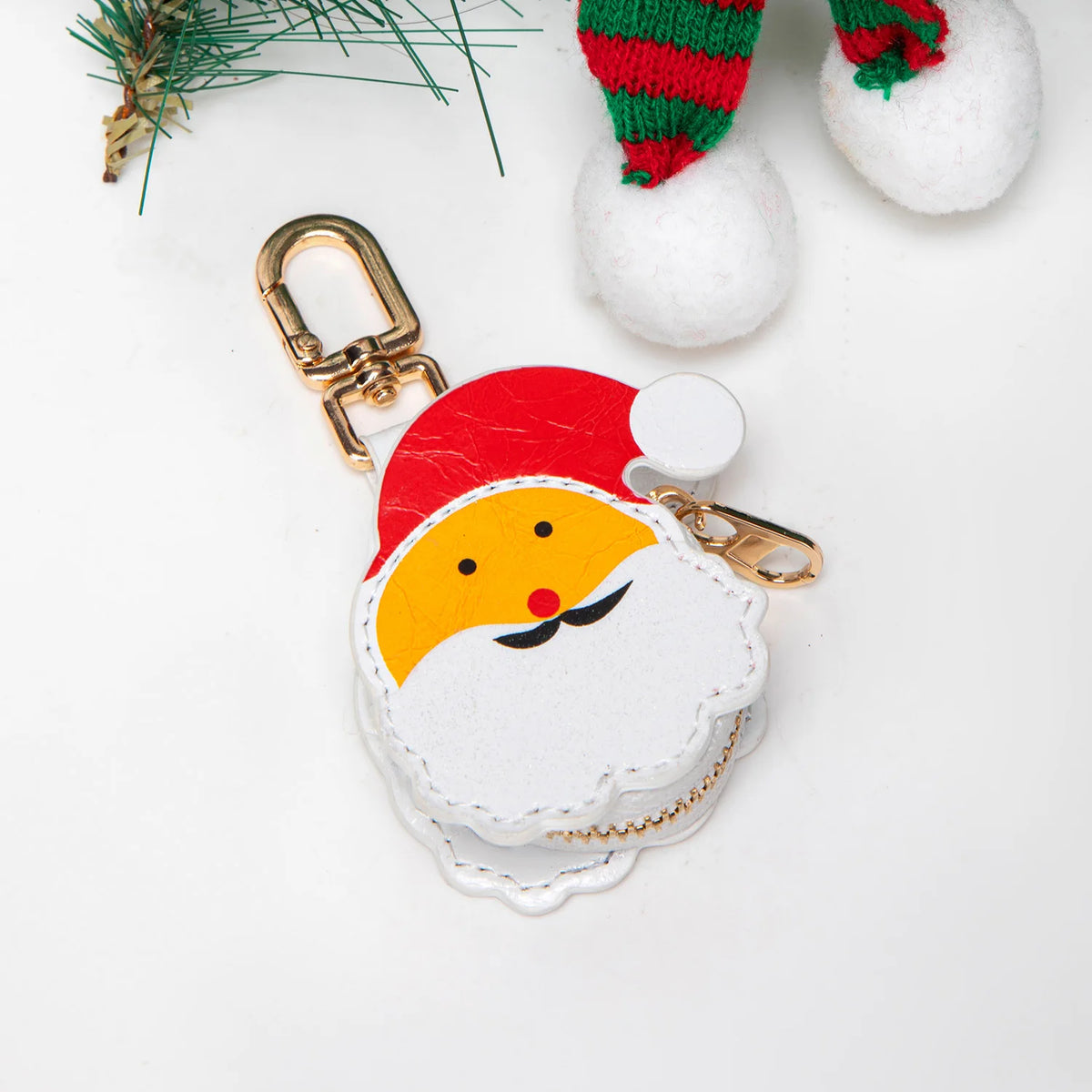 Una linda cartera de monedas con forma de calabaza, sombrero de Santa rojo y blanco y herrajes dorados.