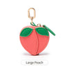 A large peach shaped coin purse keychain in coral pink with green leaves and a gold-colored hook.
