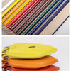 Une pile de lanières en cuir colorées et plusieurs cartes en cuir colorées sont exposées.
