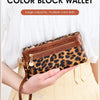 A brown leopard print block wallet is held by a person against a light yellow background.