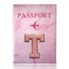 A pink marbled passport cover featuring a gold letter T embossed on the front.