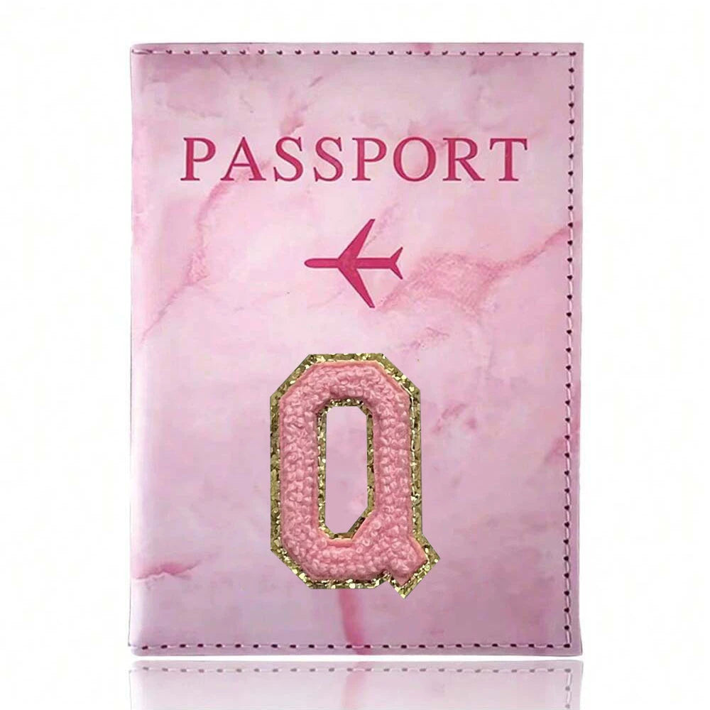 A pink marbled leather passport cover featuring a gold embroidered letter O.