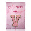 A pink marbled passport cover featuring a gold initial V and the word PASSPORT.