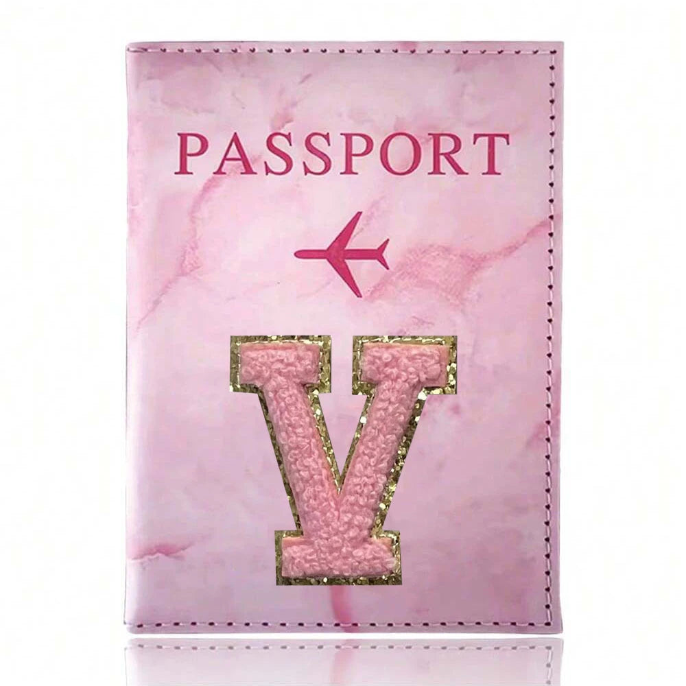 A pink marbled passport cover featuring a gold initial V and the word PASSPORT.