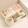 A beige storage bag for travel hair dryers and styling tools with partitioned compartments.