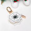 Llavero cartera de monedas de calabaza tono dorado con patrón de panal blanco y diseño de araña negra.
