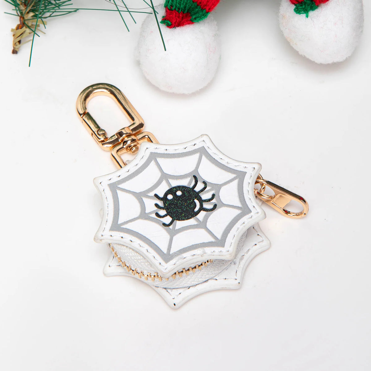 Llavero cartera de monedas de calabaza tono dorado con patrón de panal blanco y diseño de araña negra.