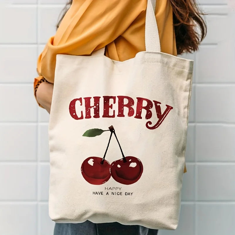 A canvas tote bag featuring a red cherry print with the text Happy Have a Nice Day