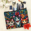 A colorful makeup pouch featuring a cat design with vibrant floral patterns and various cosmetic tools.