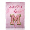 Pink marbled passport cover featuring a gold embroidered letter M and a pink airplane symbol