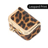 Una pequeña caja de terciopelo con estampado de leopardo para guardar joyas, con detalles dorados.