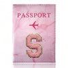 Pink marbled passport cover featuring a gold initial S and a pink airplane symbol