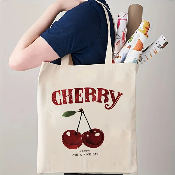 A beige canvas tote bag featuring a red cherry print and the text Happy Have a Nice Day.