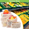 Reusable cotton mesh produce bags filled with various fruits and vegetables like oranges, lemons, and apples