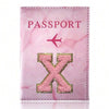 Pink marbled passport cover featuring a pink embroidered X design and a small airplane symbol