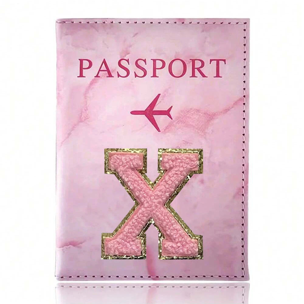 Pink marbled passport cover featuring a pink embroidered X design and a small airplane symbol
