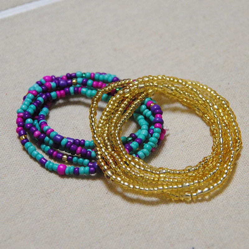 A collection of colorful belly bead chains featuring purple, pink, and turquoise beads.