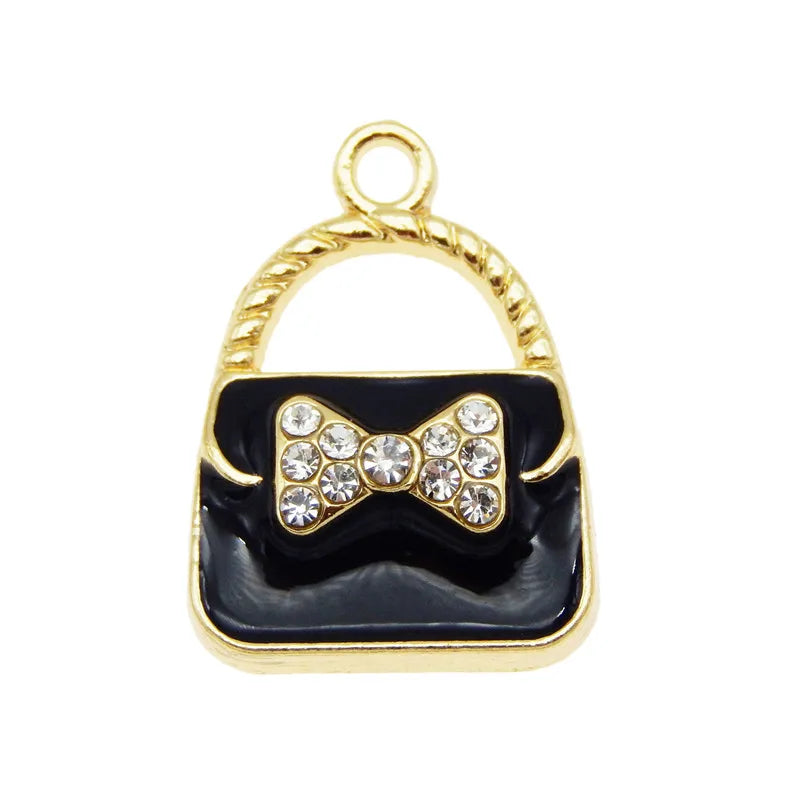 Charm à sac ton or avec boucle et corps en émail noir décoré de cristaux clairs.