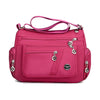 A bright pink waterproof nylon crossbody tote bag with a pink strap and silver hardware.