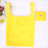 A bright yellow eco-friendly foldable shopping bag is displayed next to a white background.