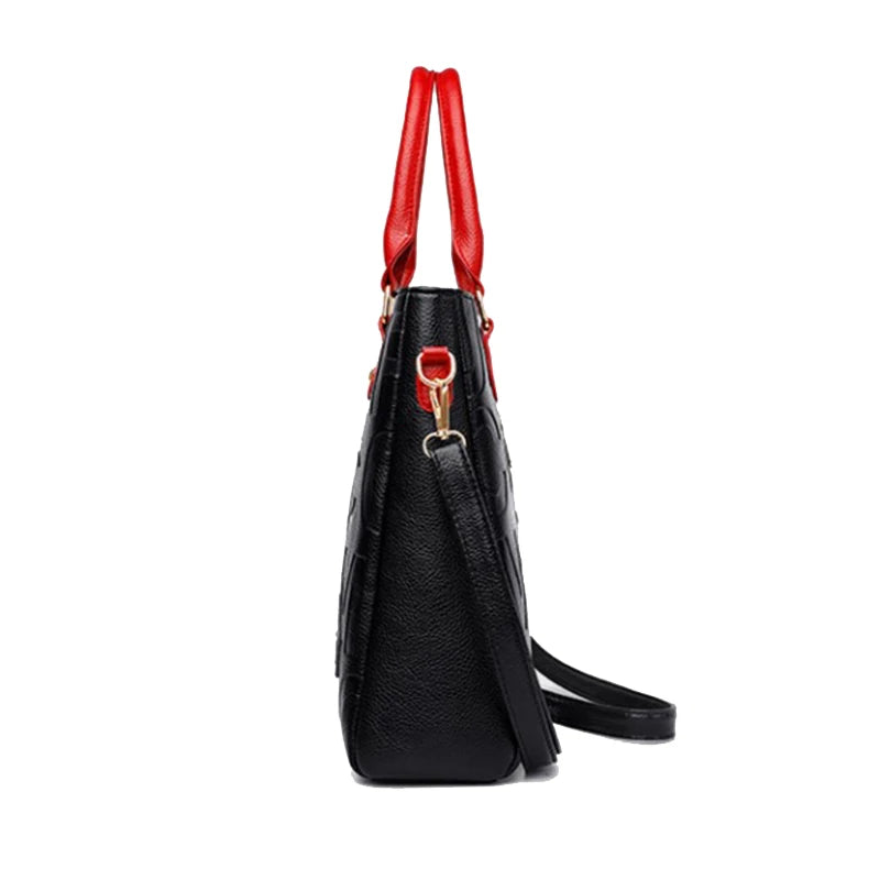 Sac bandoulière en cuir PU noir avec anses en cuir rouge, vue de côté.