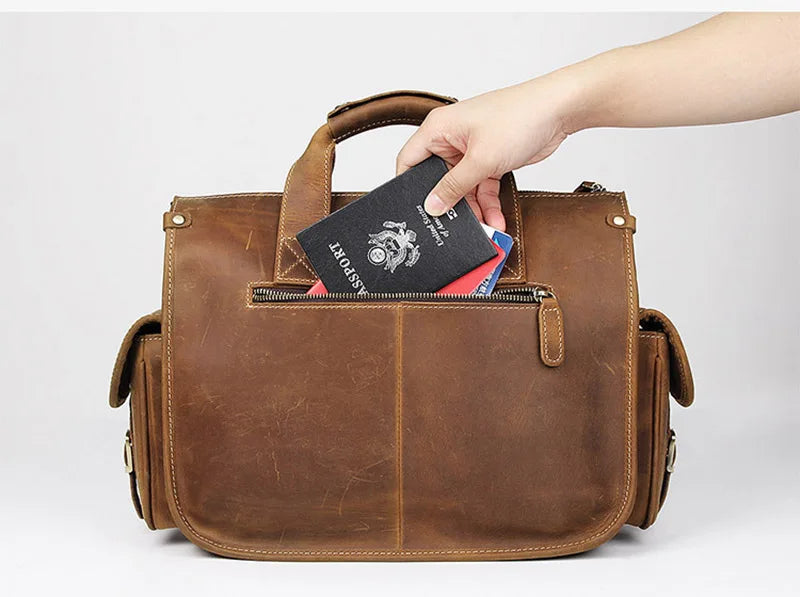 A hand is placing an passport into the zippered compartment of a brown genuine cowhide leather briefcase.