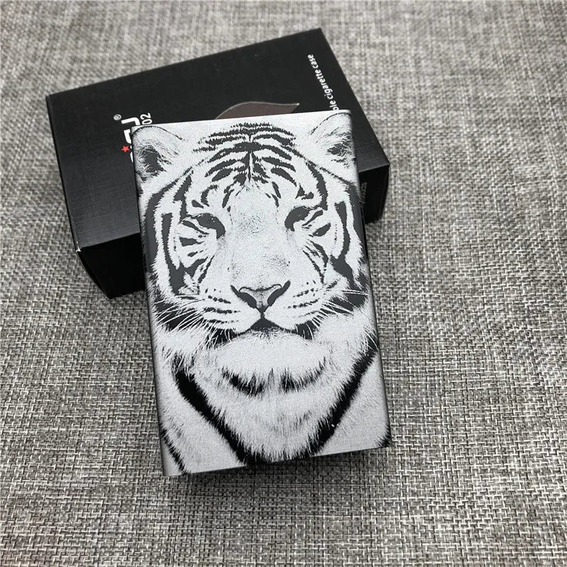 A black box holds a custom engraved cigarette case featuring a detailed white tiger face design.