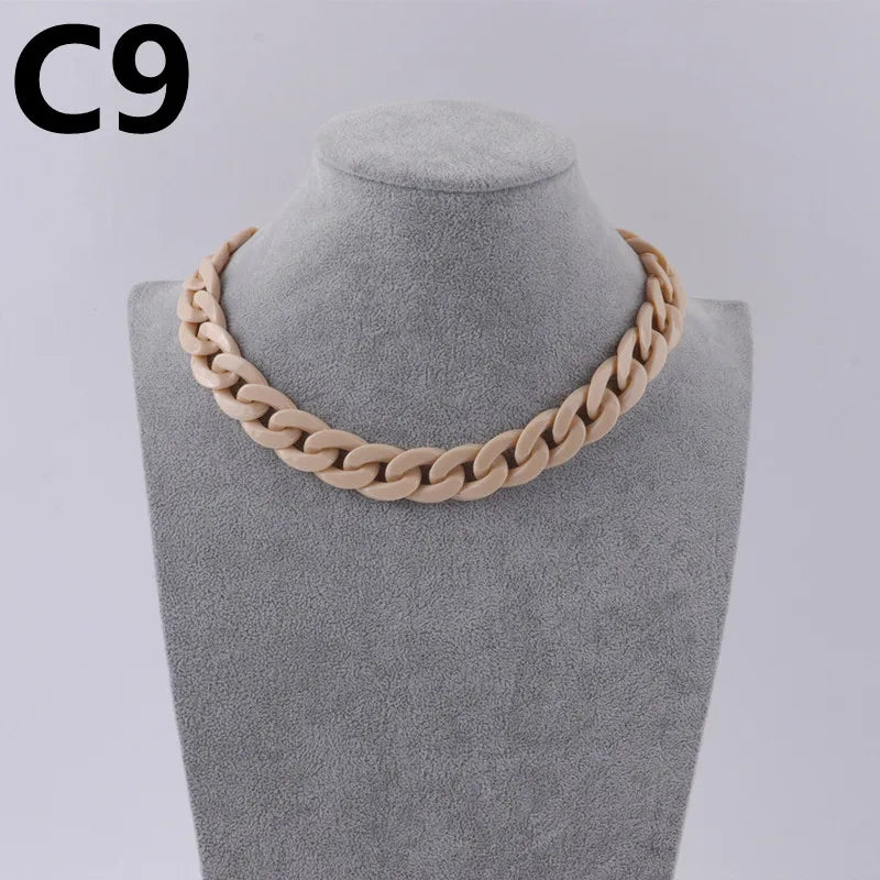 A close-up of a beige acrylic link chain necklace displayed on a mannequin neck.