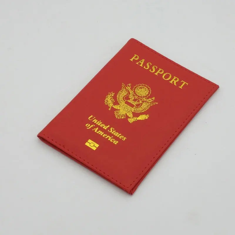 A red leather passport holder with gold lettering and an embossed eagle design.