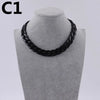 A black acrylic link chain necklace displayed on a mannequin neck.