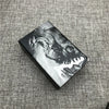 A black custom engraved cigarette case featuring a monochrome design of a fierce dragon.