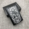 A black custom engraved cigarette case featuring a detailed lion design and the name LEO, resting on a gray fabric surface.