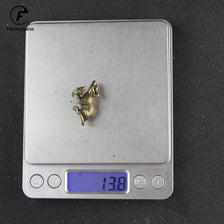 Silver digital thermometer with a vintage brass rat figurine on the display