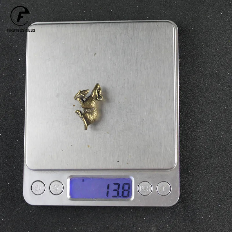 Silver digital thermometer with a vintage brass rat figurine on the display