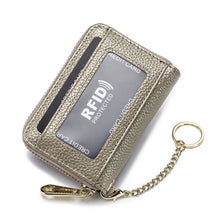 A silver leather credit card holder wallet with an RFID protected slot and a gold chain attached.