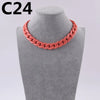 A close-up of a coral pink acrylic link chain necklace displayed on a mannequin neck.