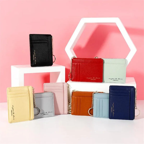 A collection of six compact PU leather zip wallets in various colors displayed on a white stand.