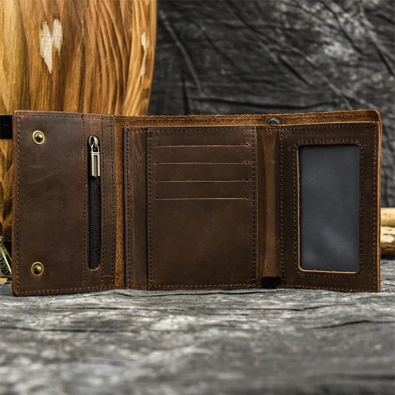 A brown genuine leather trifold wallet with a stitched closure and a dark leather card slot is displayed on a gray surface.